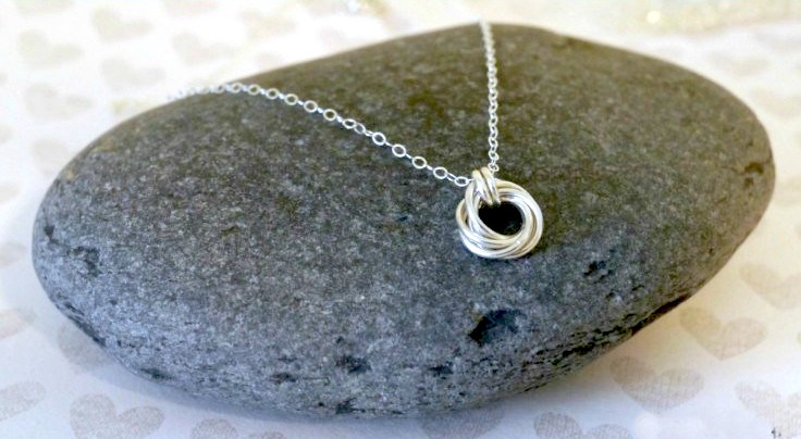 silver spiral necklace on a rock