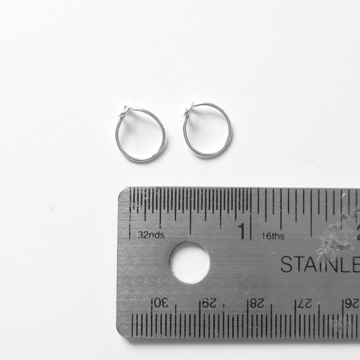 tiny sterling silver hoop huggie earrings with ruler next to them