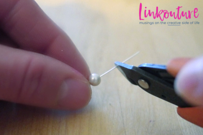 hand cutting a headpin with a pearl