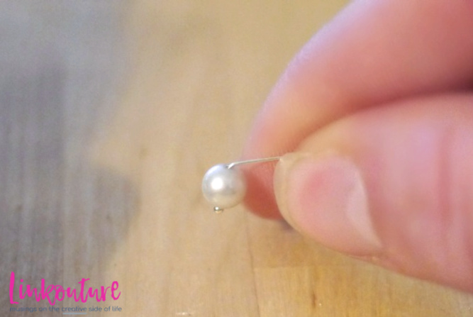 hand holding a freshwater pearl on a headpin